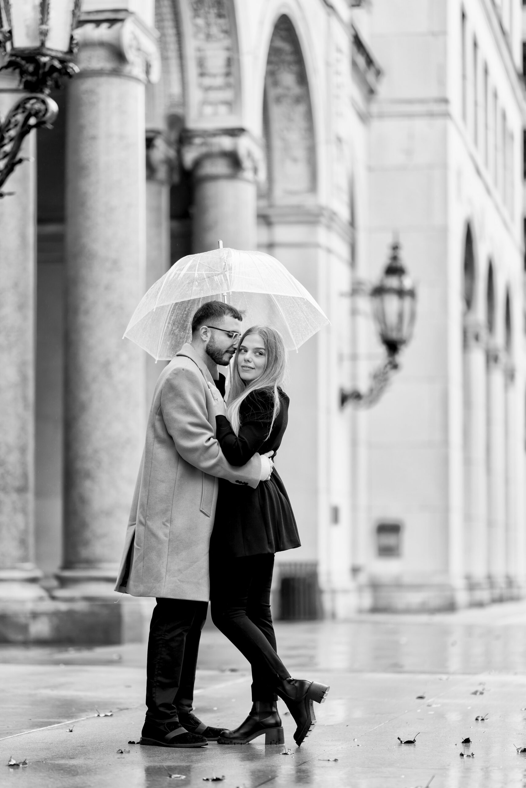 A couple kisses under an umbrella after their Cadillac Place proposal in Detroit, MI.  