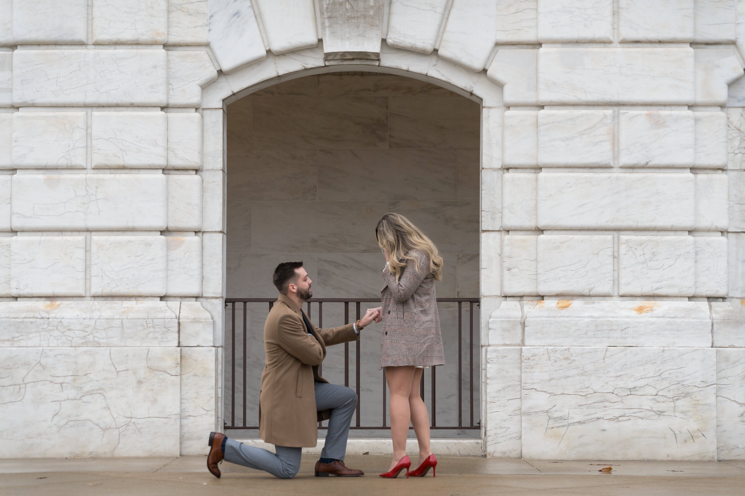 A man takes a knee, reaches into his coat pocket, and begins Detroit Institute of Arts proposal to his girlfriend.