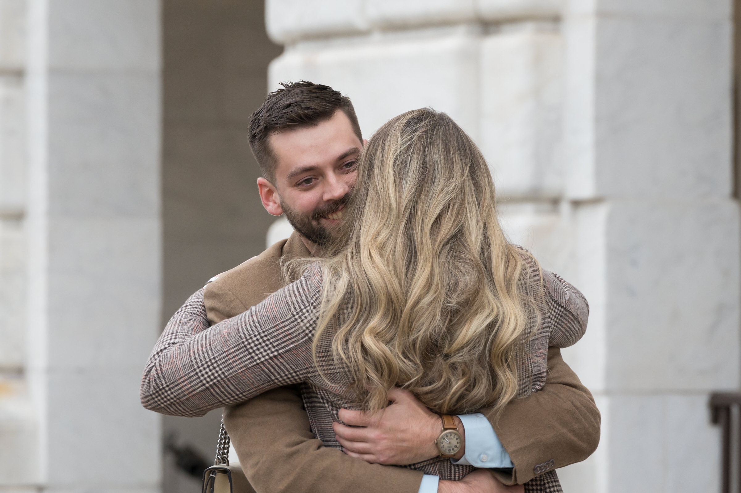 A fiance hugs and smiles after his Detroit Institute of Arts proposal.
