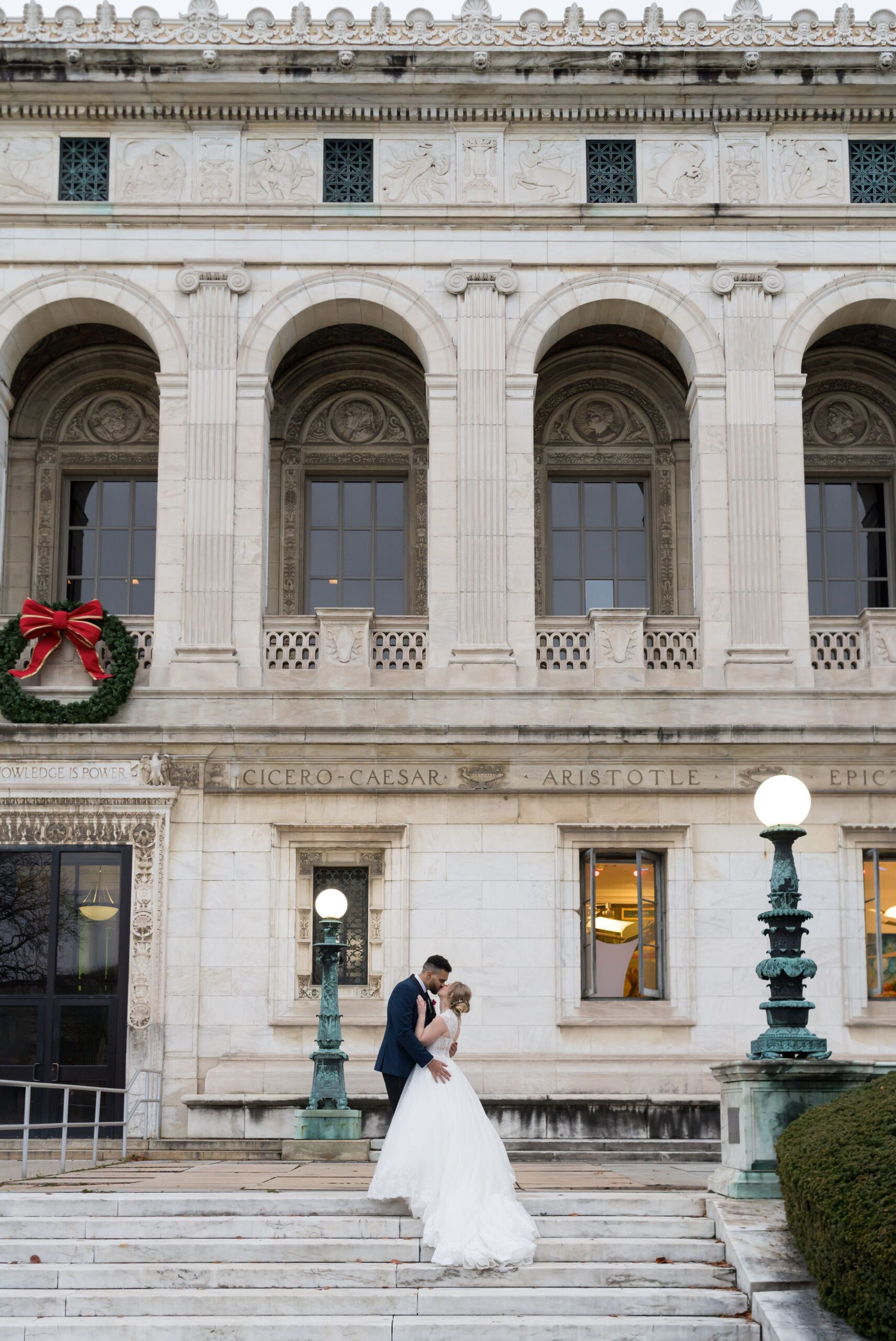 A bride and groom kiss on the steps of the Detroit Public Library on their wedding day. 