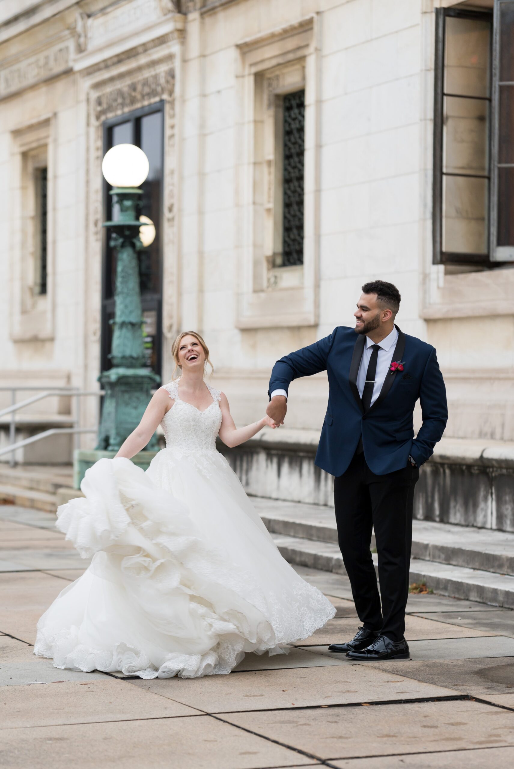 A bride twirls with the help of her husband on their wedding day at the Detroit Public Library. 