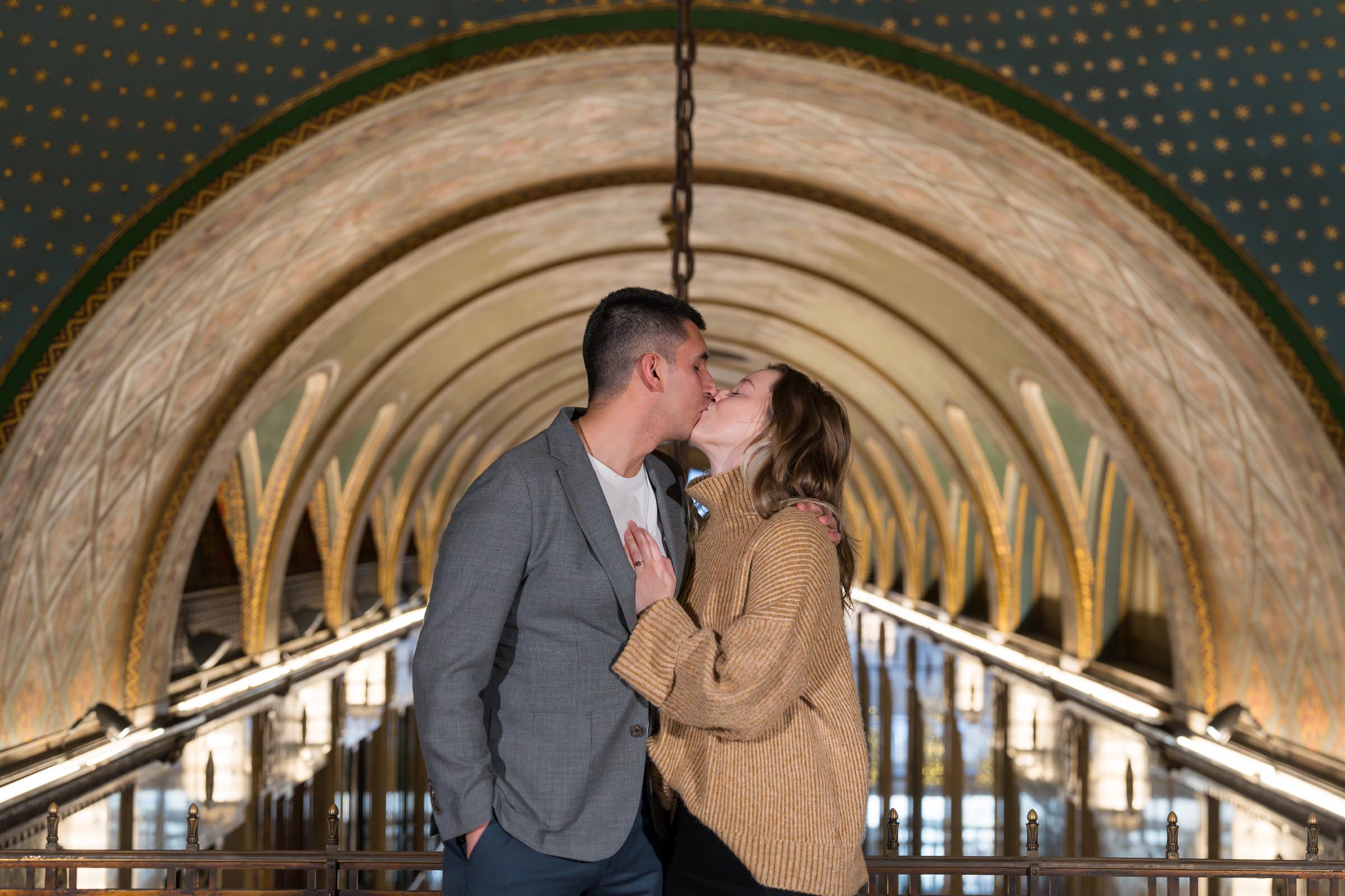 Framed by an art deco archway, a couple kisses after their Fisher Building proposal.  