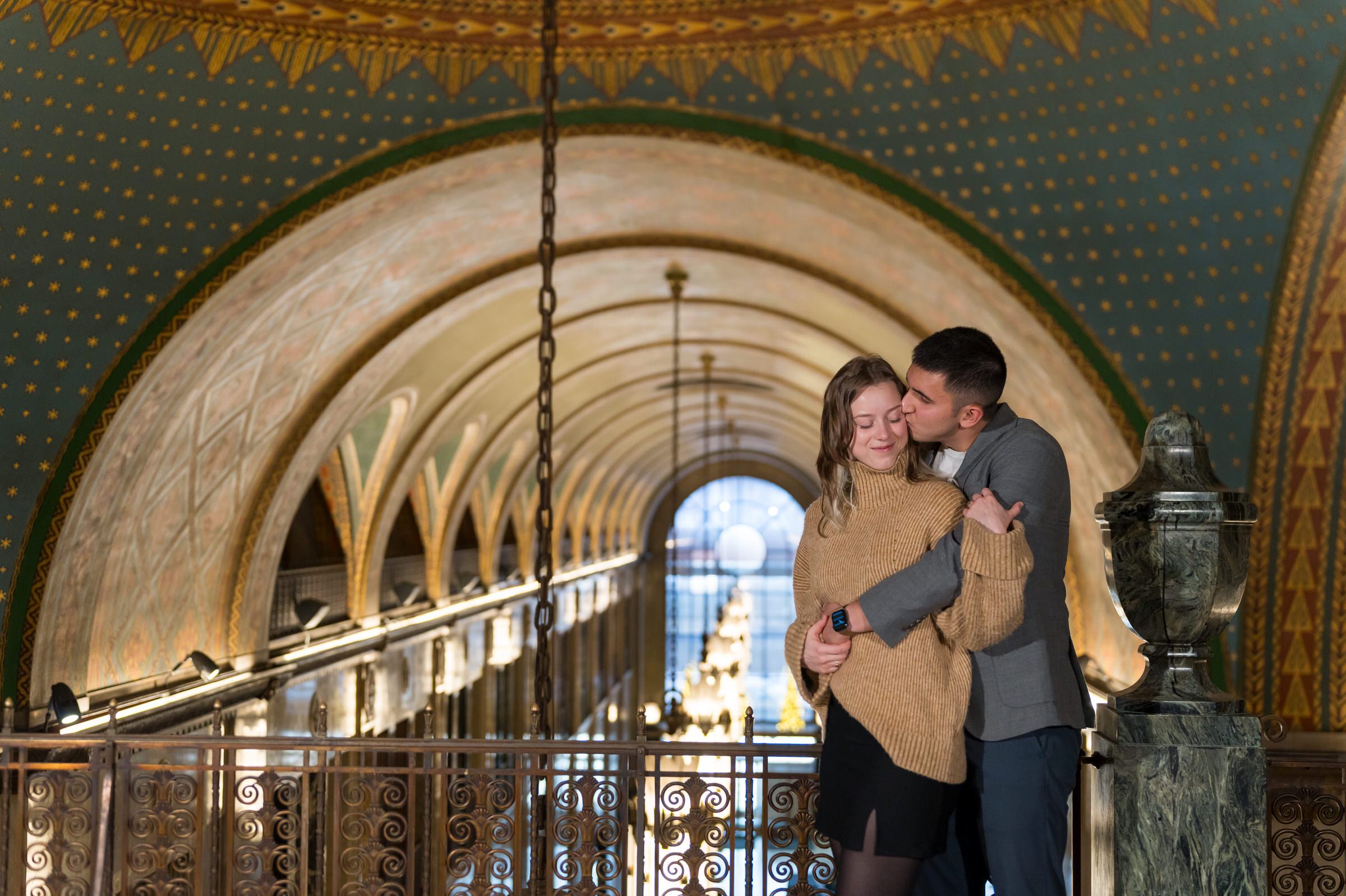 A couple snuggles up moments after their Fisher Building proposal in Detroit, Michigan. 