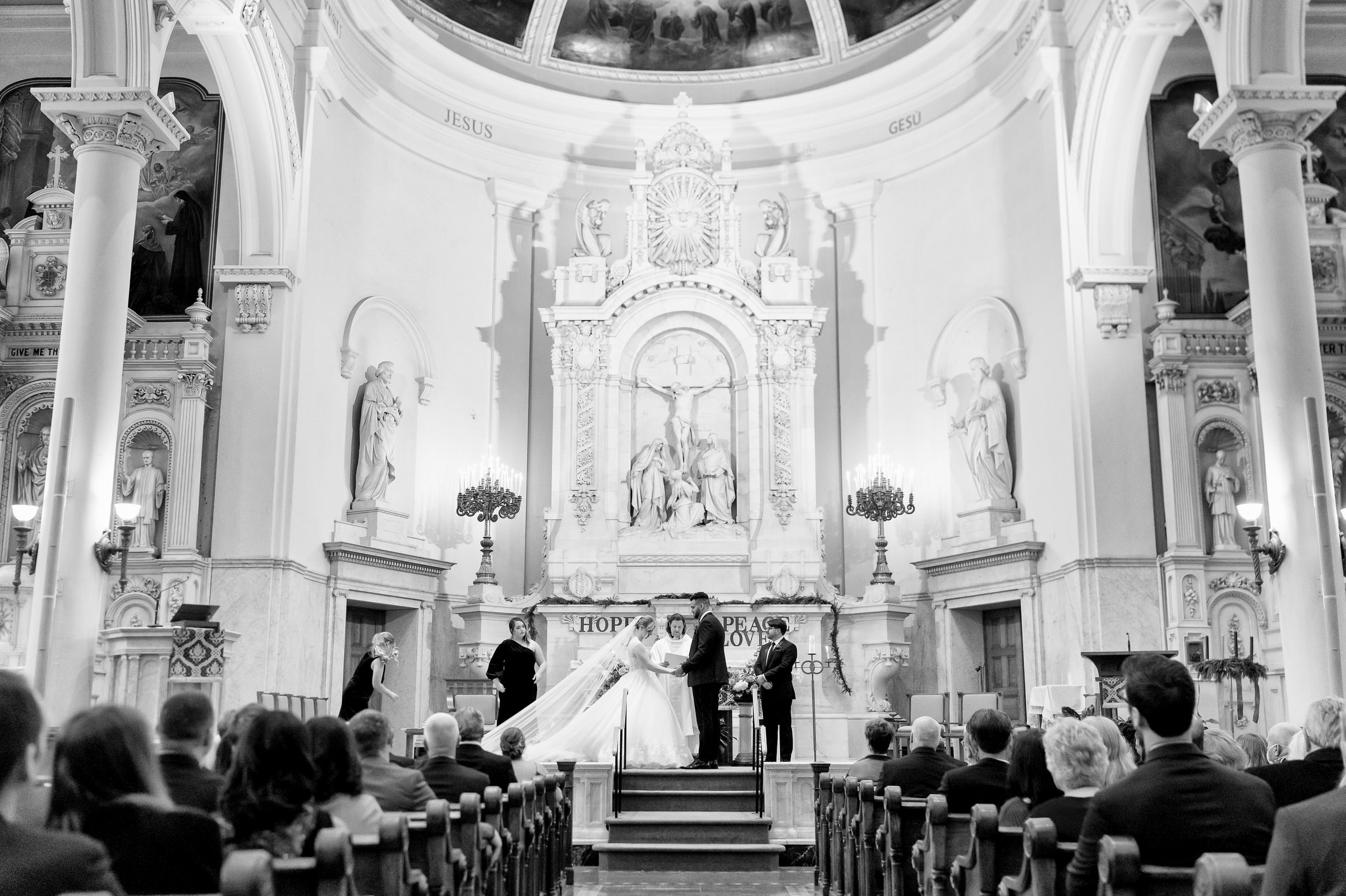 A bride and groom exchange vows at Saints Peter and Paul Jesuit Church in Detroit on their wedding day.  
