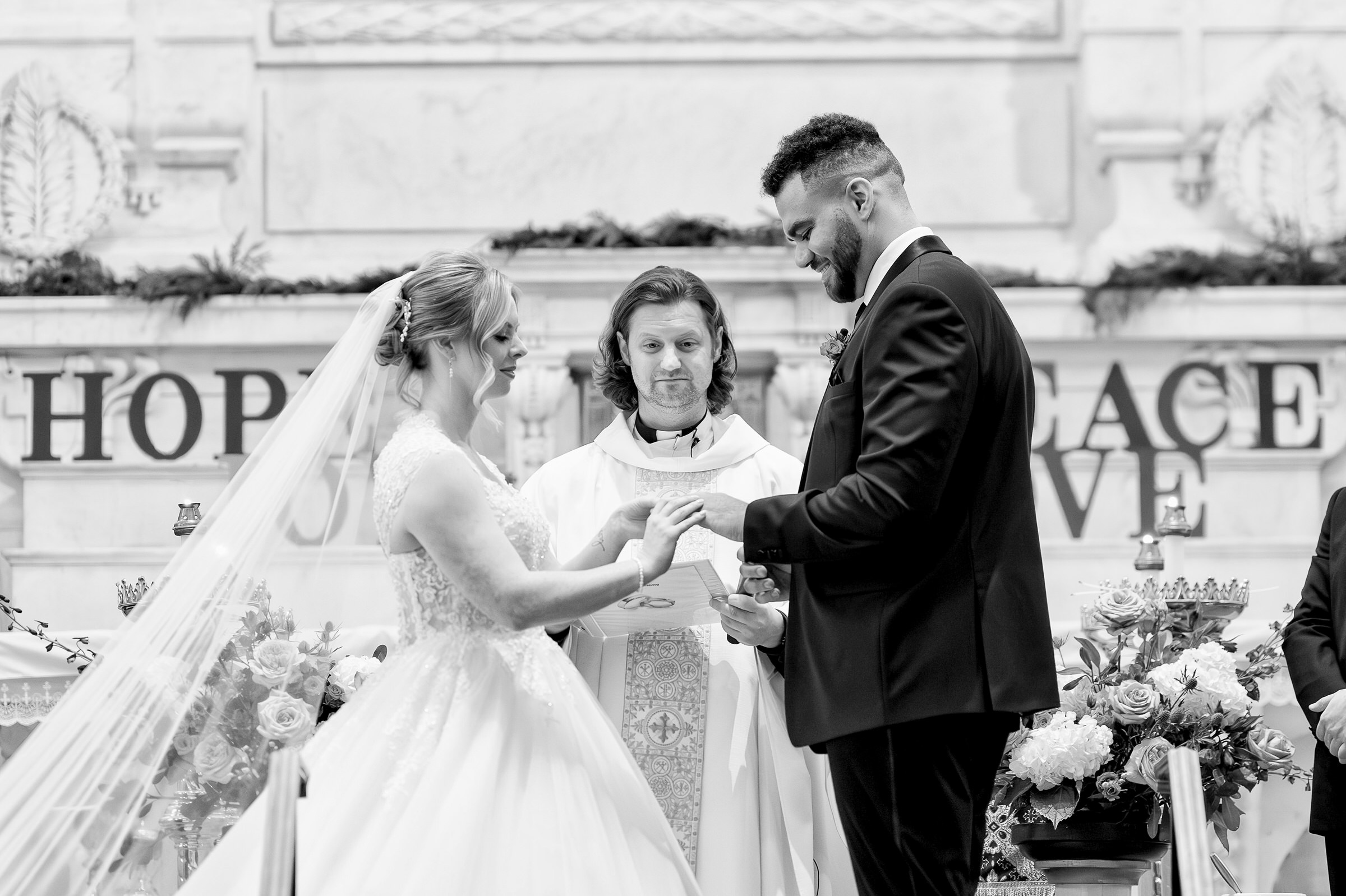 A bride and groom exchange rings at Saints Peter and Paul Jesuit Church in Detroit on their wedding day.  