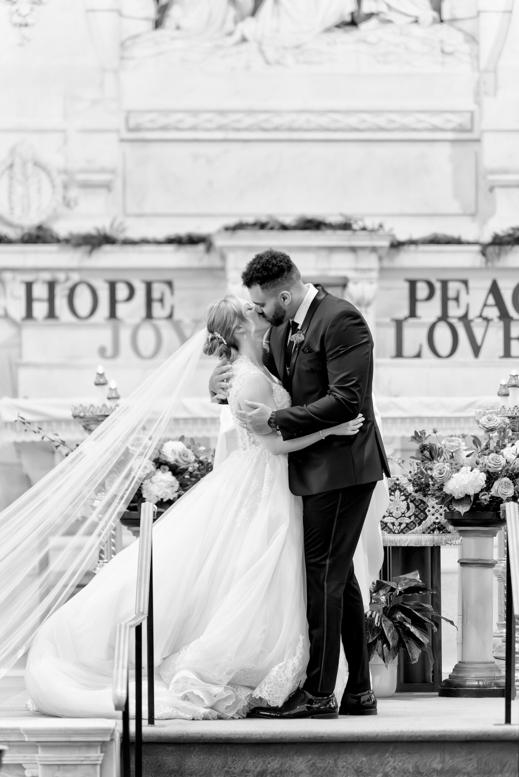 A bride and groom kiss at the altar Sts Peter and Paul Jesuit Church in Detroit on their wedding day.  