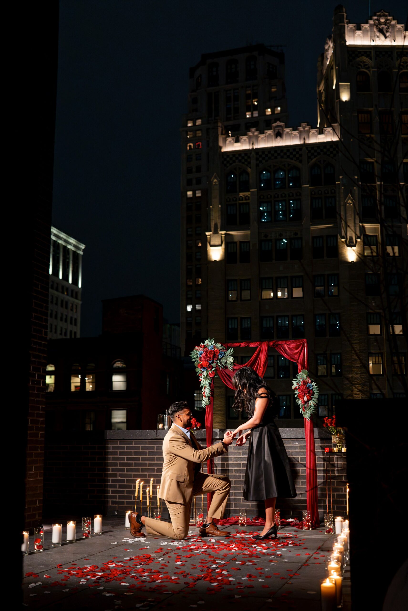 A gentleman takes a knee and puts a ring on his fiancee during their rooftop Shinola Hotel proposal. 