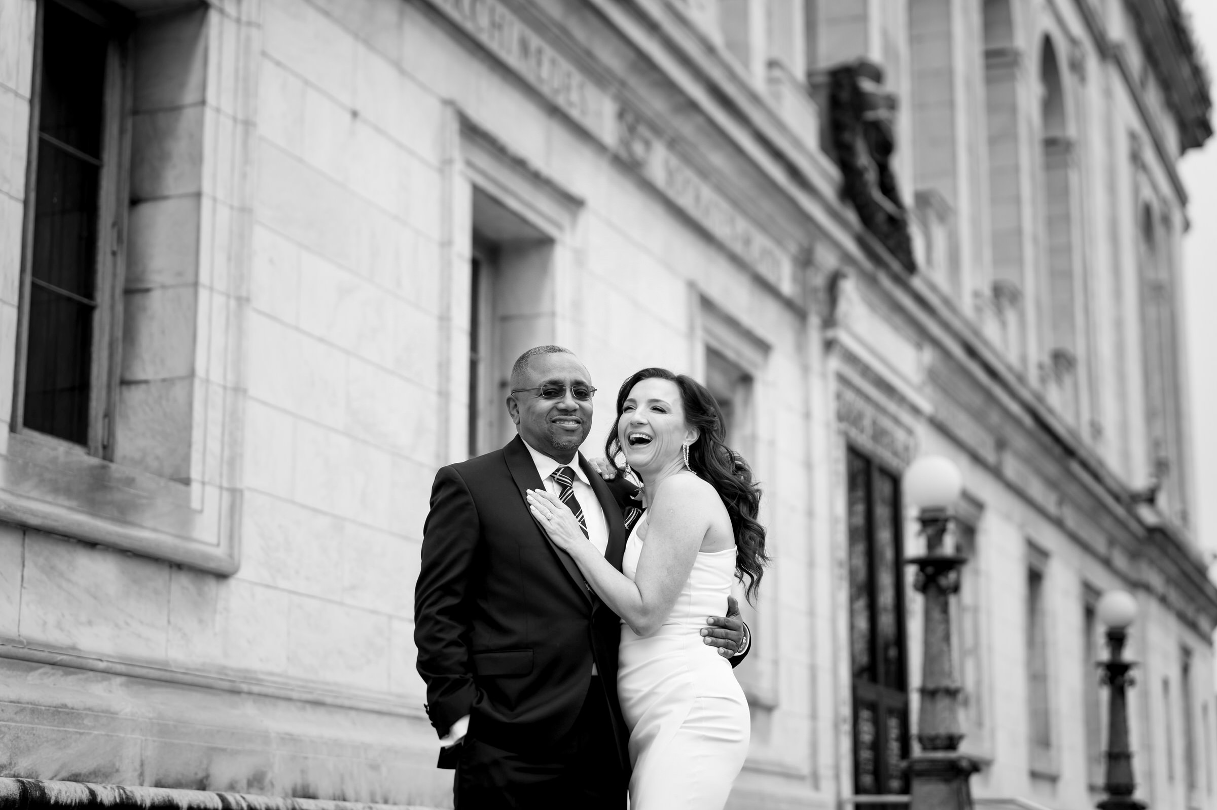 A bride and groom share a laugh on their wedding day outside of the Detroit Public Library on Woodward Ave.  