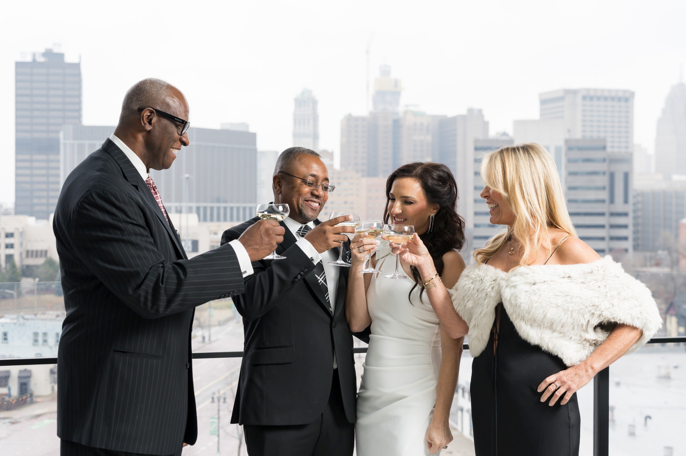 Friends offer a toast at IO Rooftop Lounge after a Godfrey Hotel wedding in Detroit.  