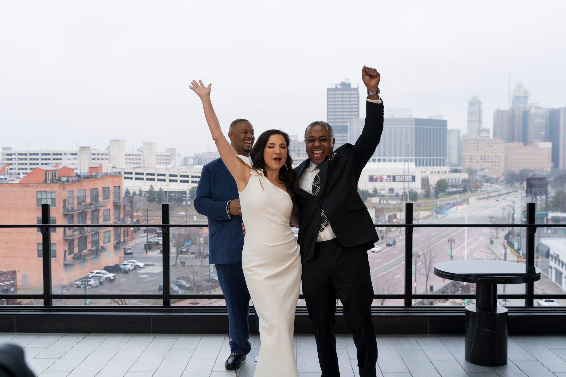 A newlywed couple celebrated with the Detroit skyline in the background after their Godfrey Hotel wedding. 