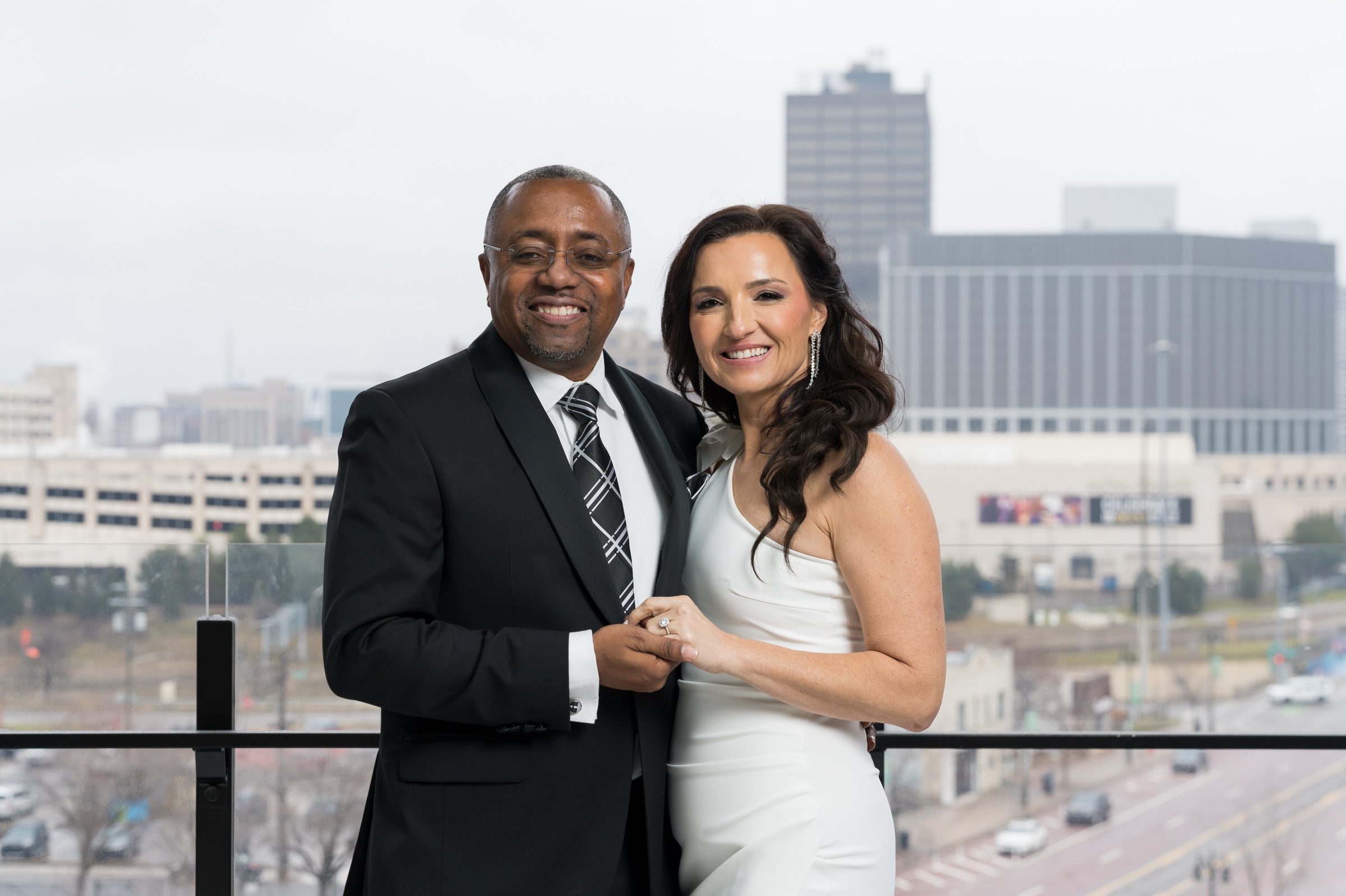 A newlywed couple poses with the Detroit skyline in the background after their Godfrey Hotel wedding. 