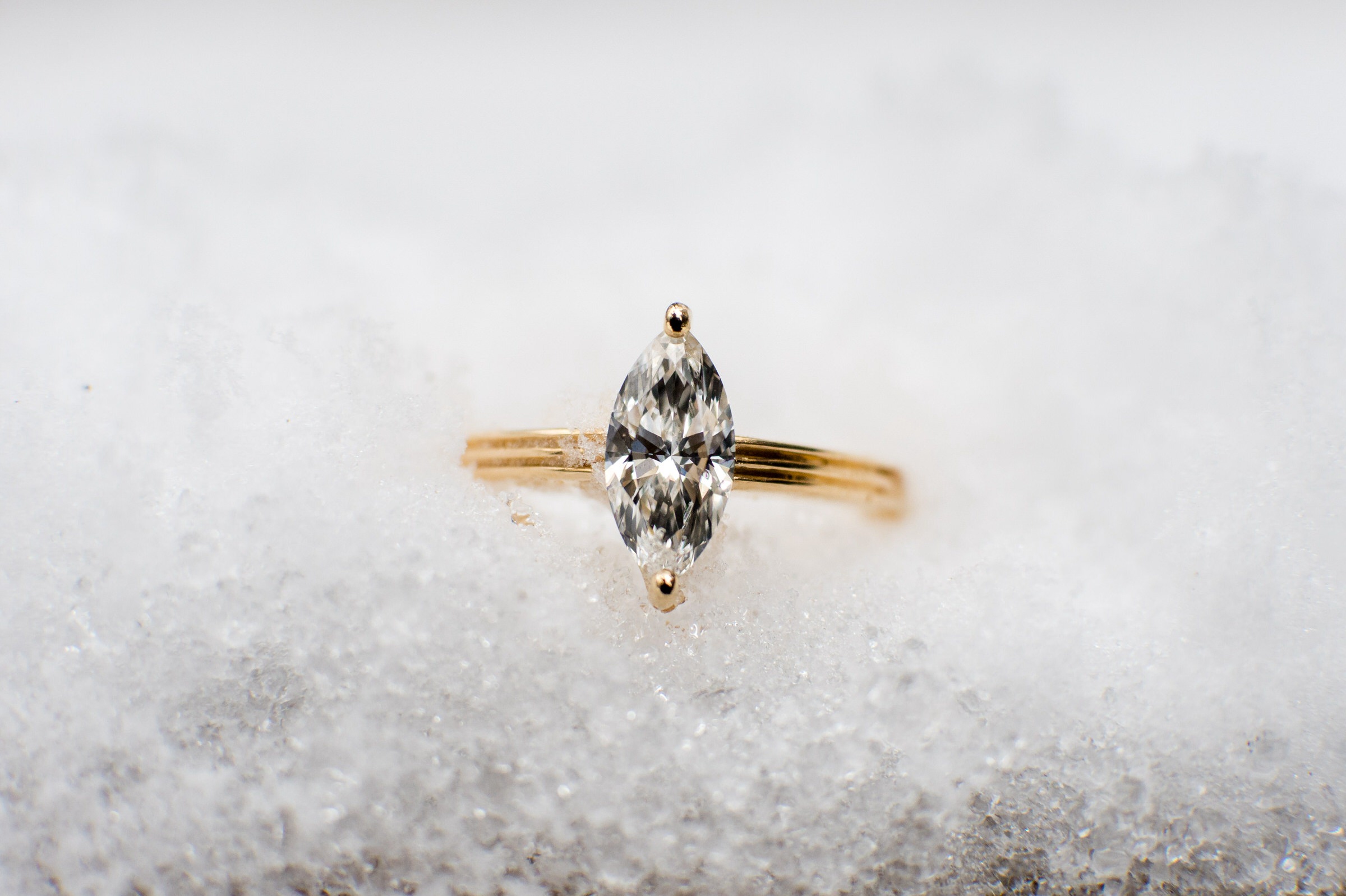 A diamond engagement ring in the snow.  