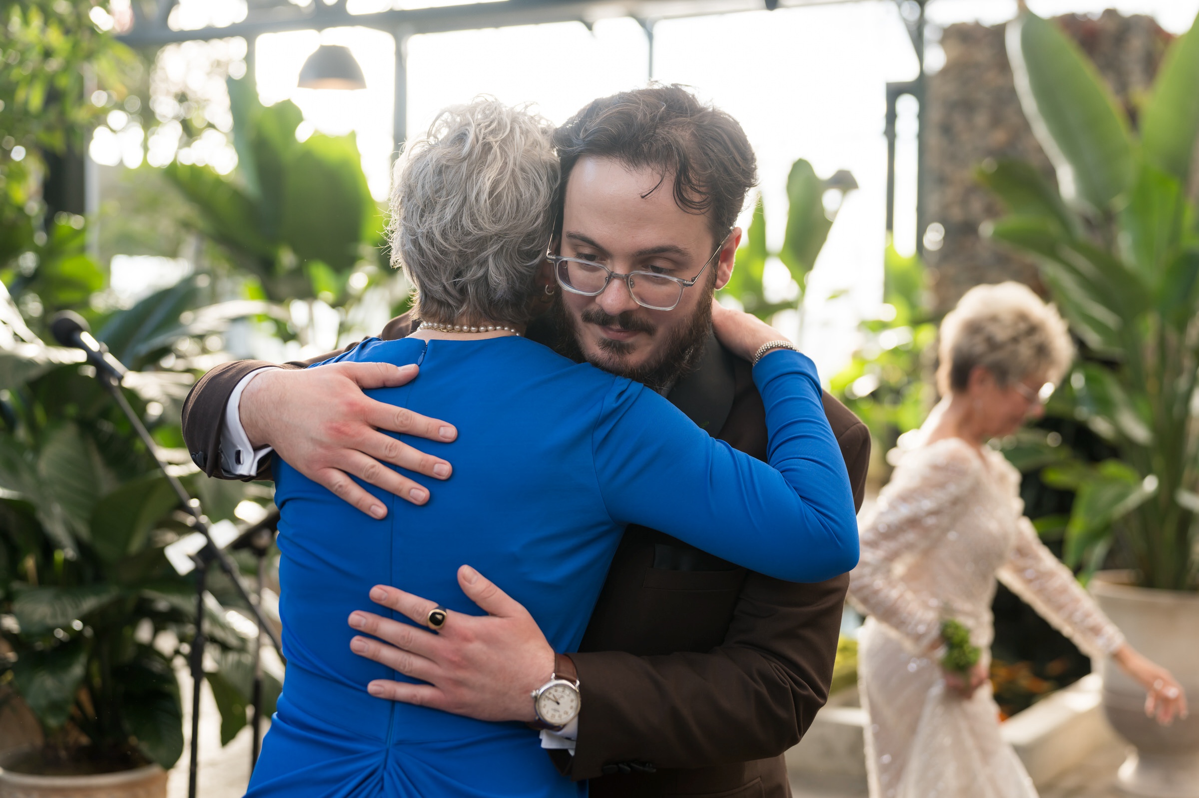 A mom hugs her son after walking down the aisle at his Planterra wedding.  