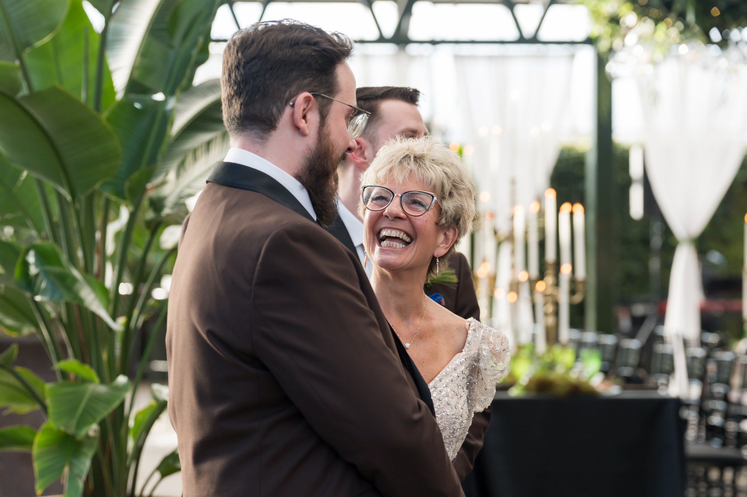 A mom reacts to seeing the bride walk down the aisle at her son's Planterra wedding.  
