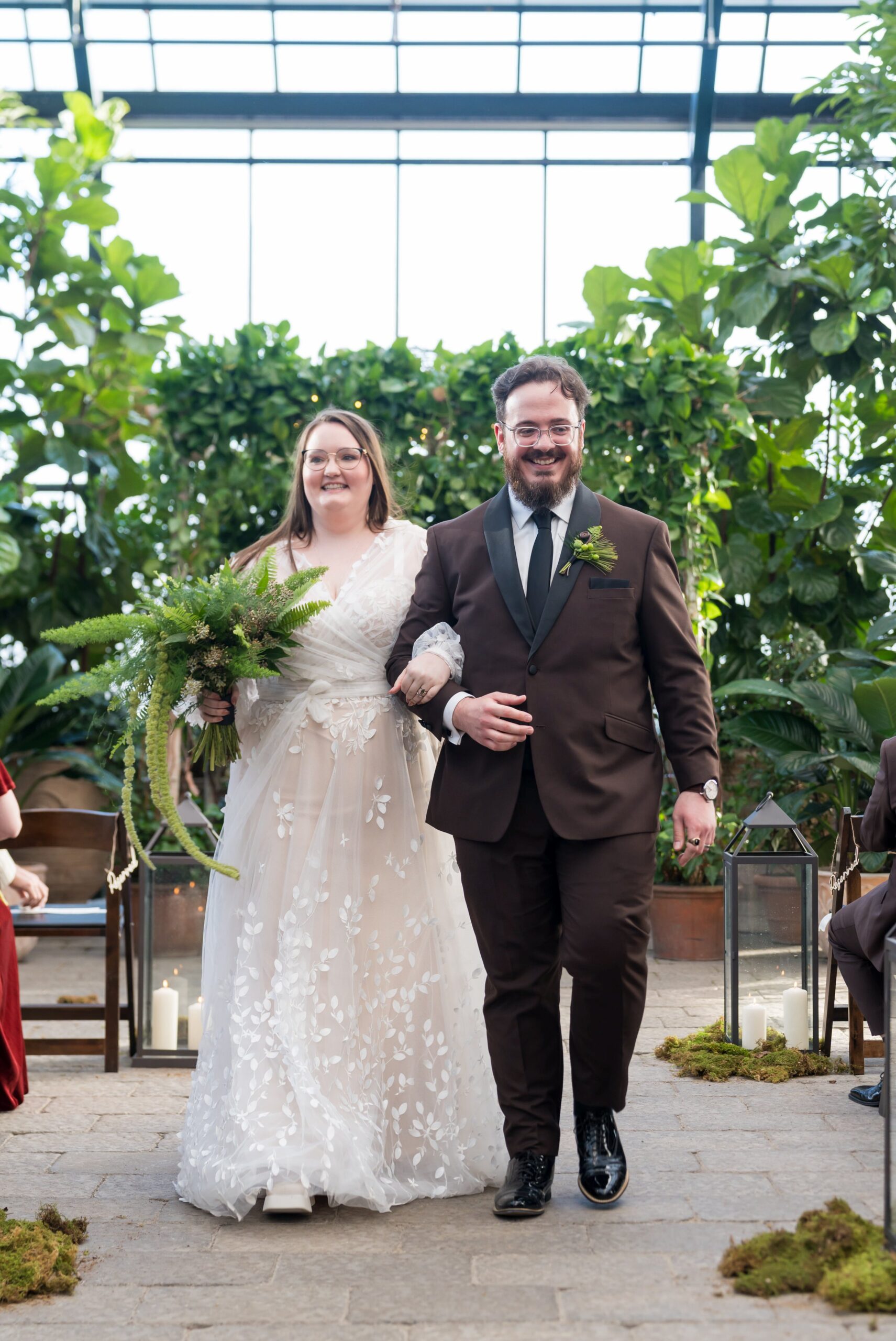 A bride and groom walk down the aisle during their Planterra wedding ceremony.   