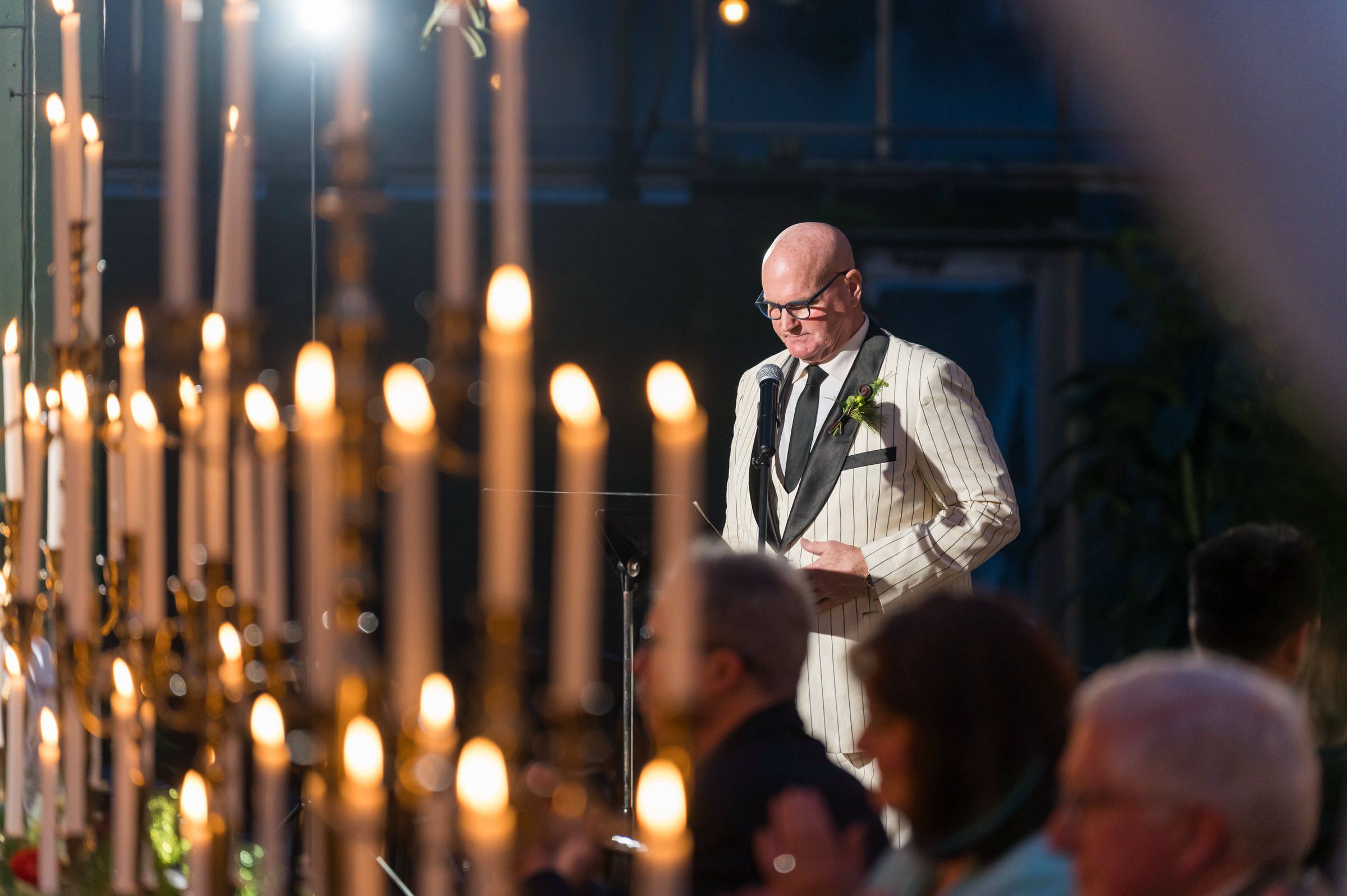 The father of the bride gives a speech in a candle-filled room at a Planterra wedding in West Bloomfield, MI. 