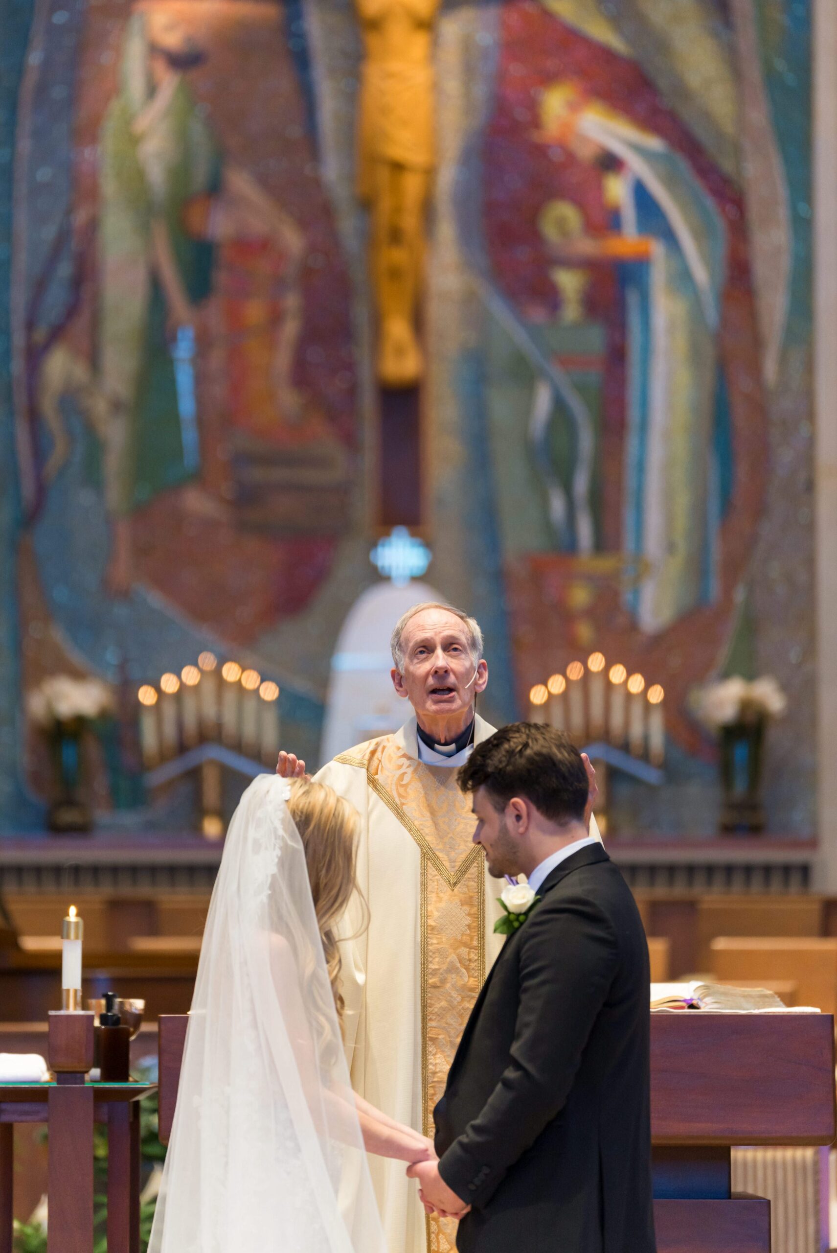 The priest blesses the married couple at a Holy Name Catholic Church wedding in downtown Birmingham.