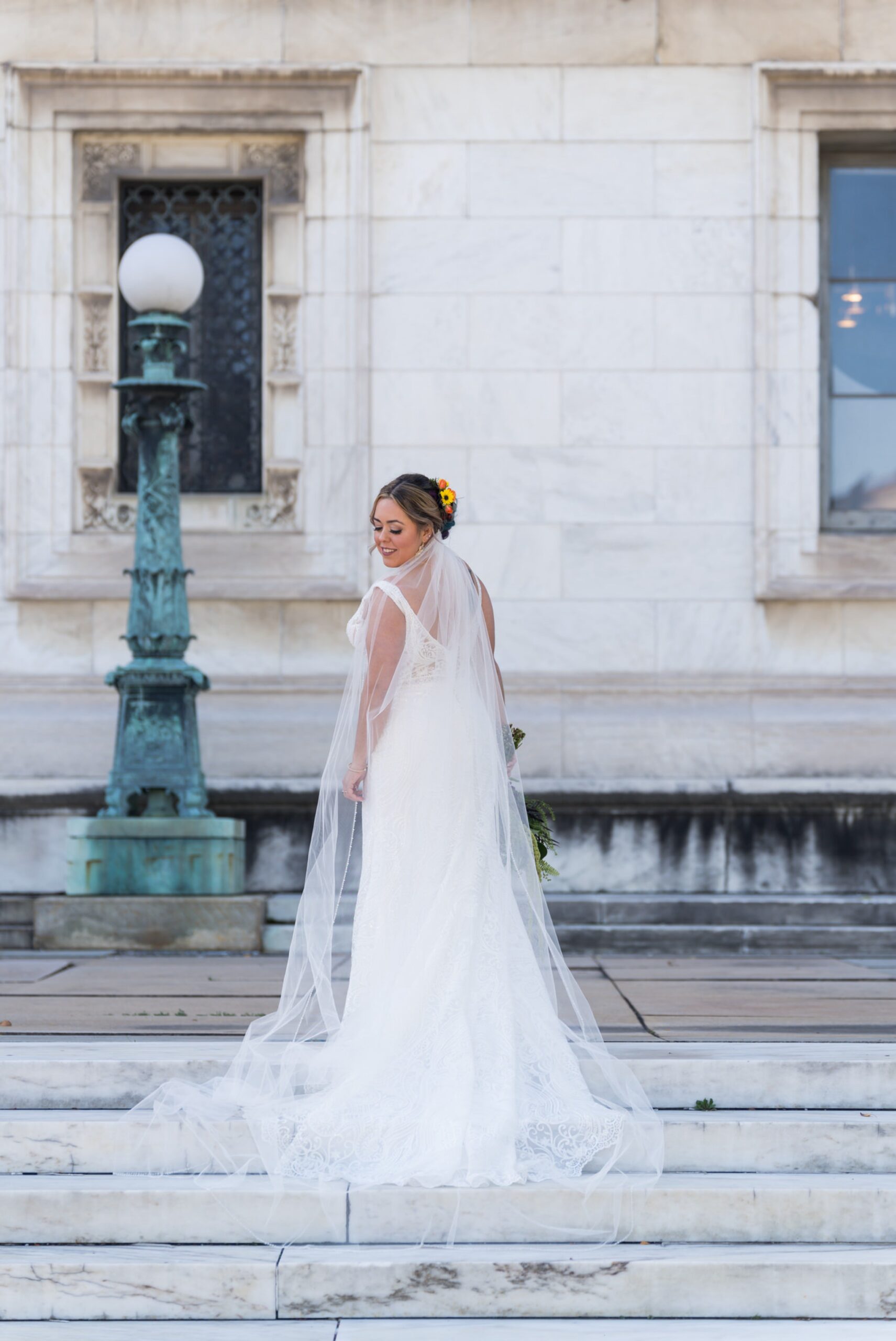 A bride poses on the steps of the Detroit Public Library on Woodward on her wedding day.  