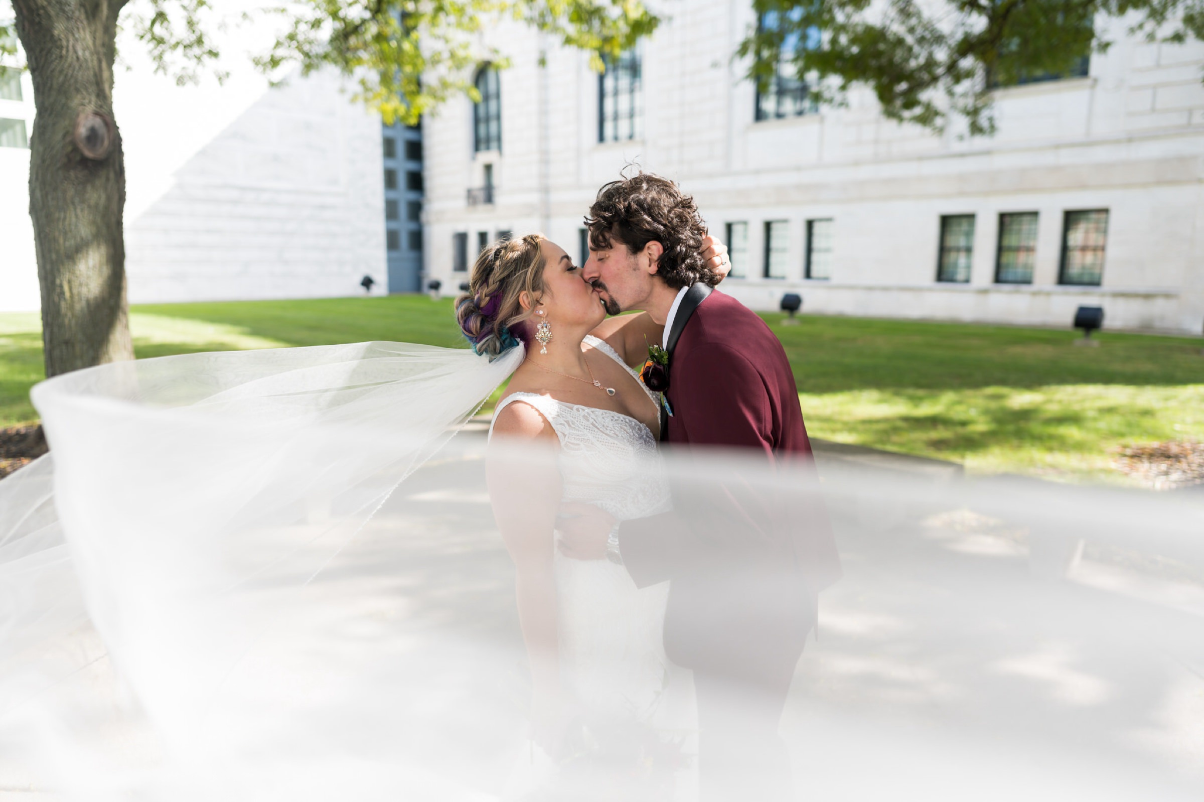 A bride and groom kiss outside of the DIA in Detroit on their wedding day.  