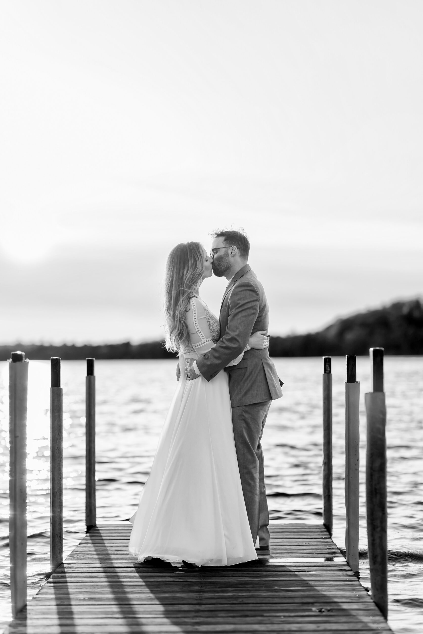 Newlyweds kiss on a dock at their Traverse City wedding.  