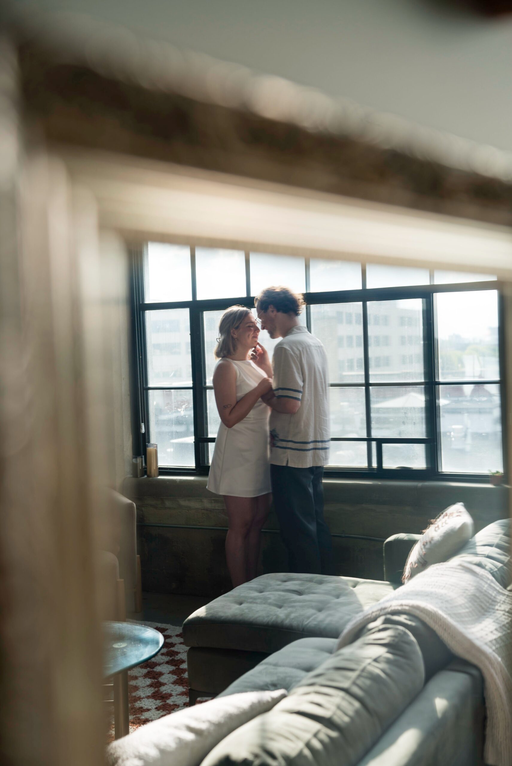 A mirrored reflection of a couple almost kisses during their Detroit lifestyle engagement session.  