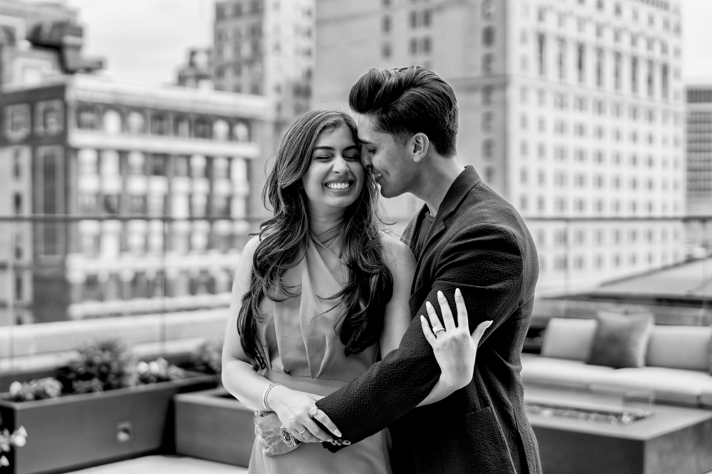 A couple poses during their engagement session at Kamper's rooftop lounge in Detroit.  