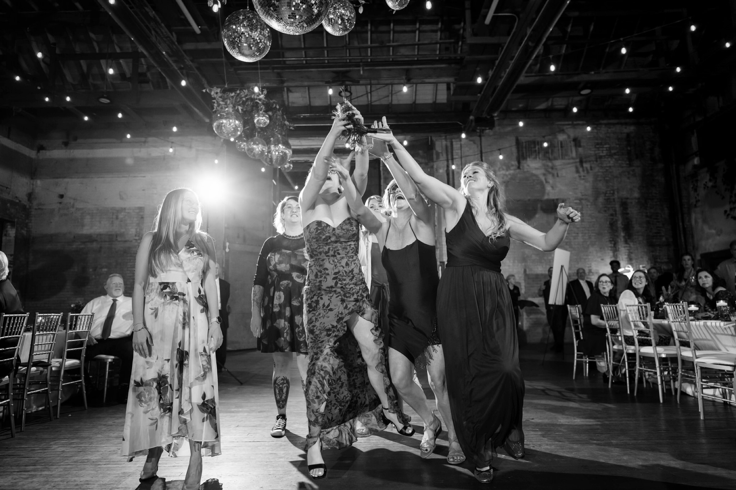 Guests jump for a bouquet during at Jam Handy wedding.  