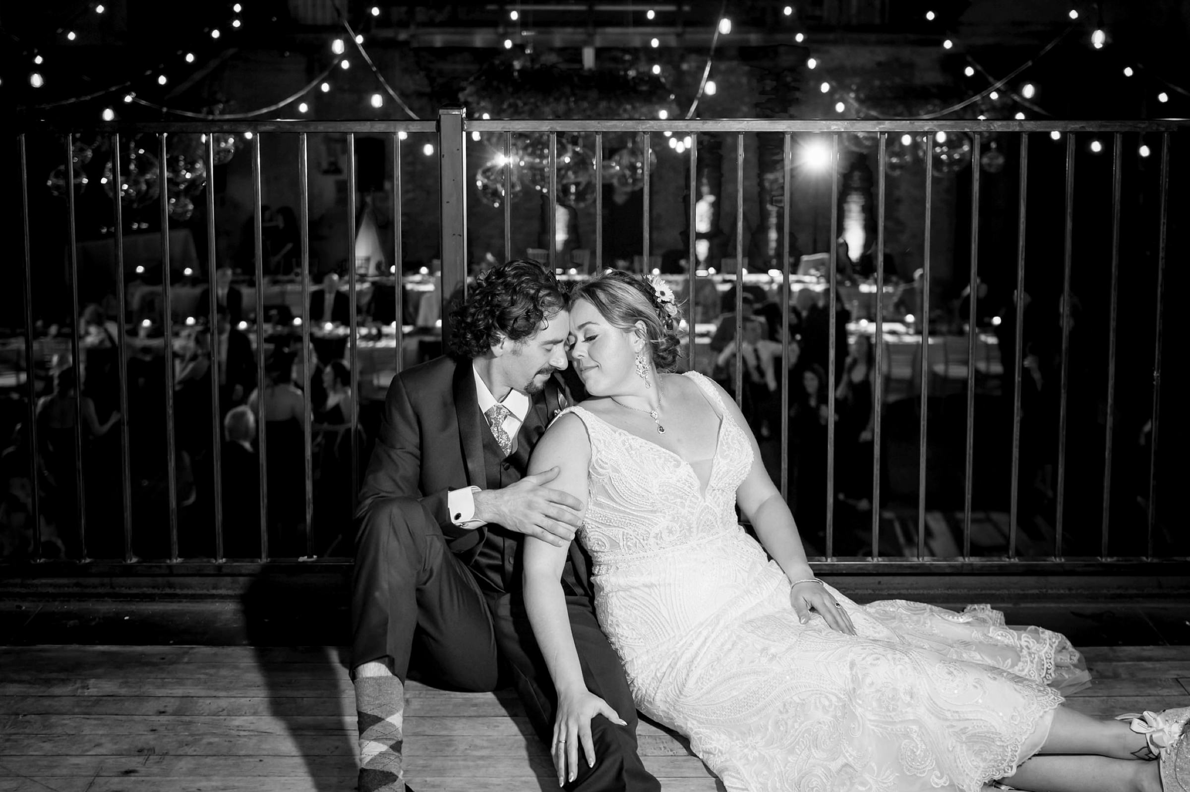 Newlyweds sit on a balcony overlooking the dance floor at the end of their Jam Handy wedding.  