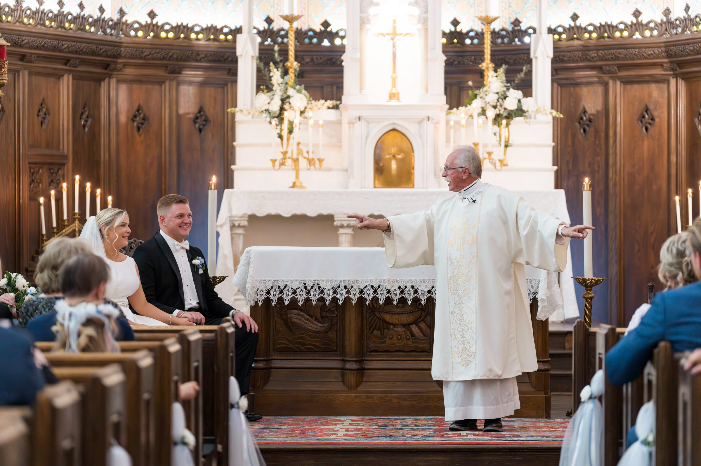 Priests speaks during ceremony with bride and groom 