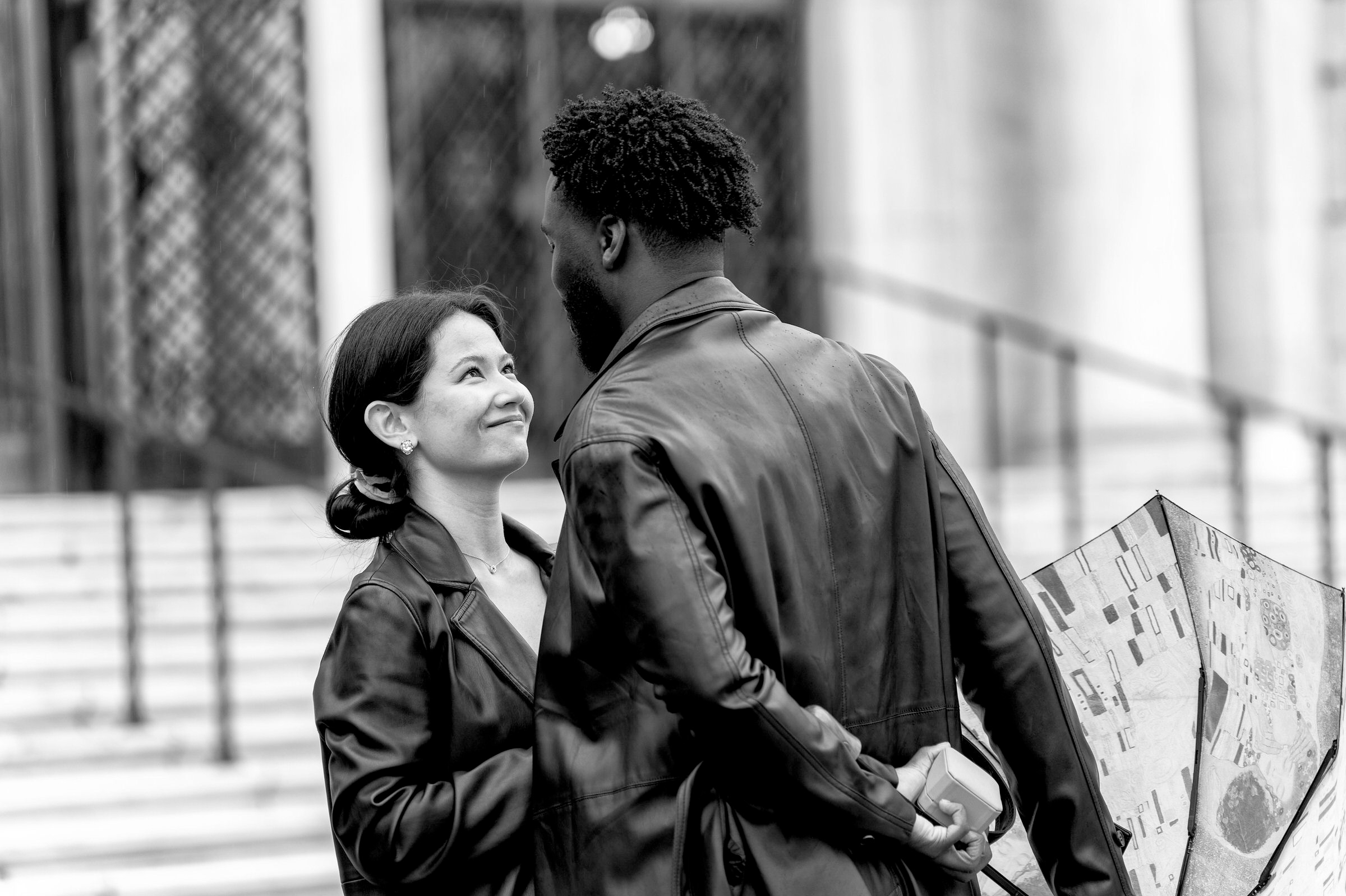 woman smiles at man during man rainy proposal at Detroit Institute of Arts 