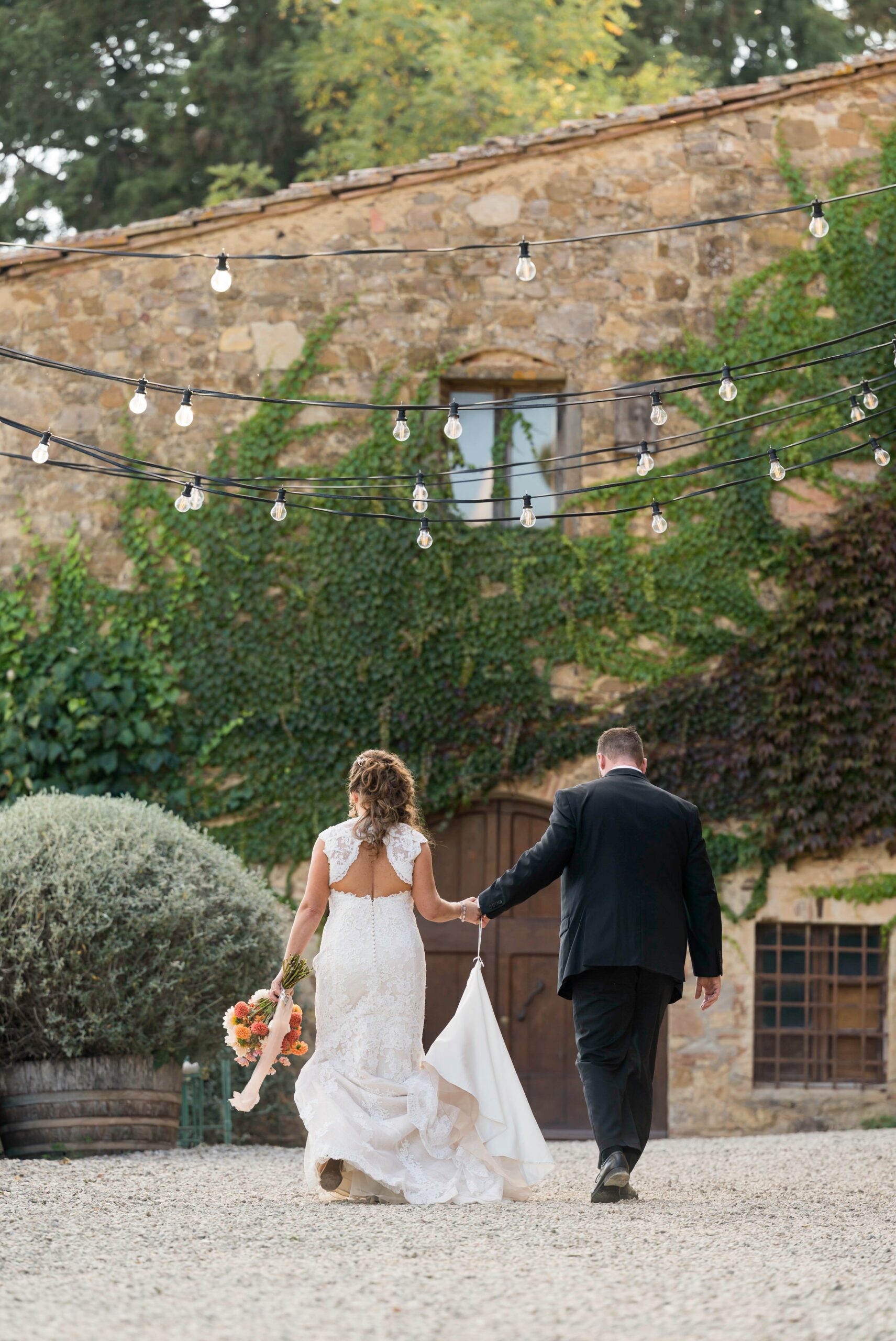 Bride and groom walk towards their celebration during Quercia al Poggio wedding