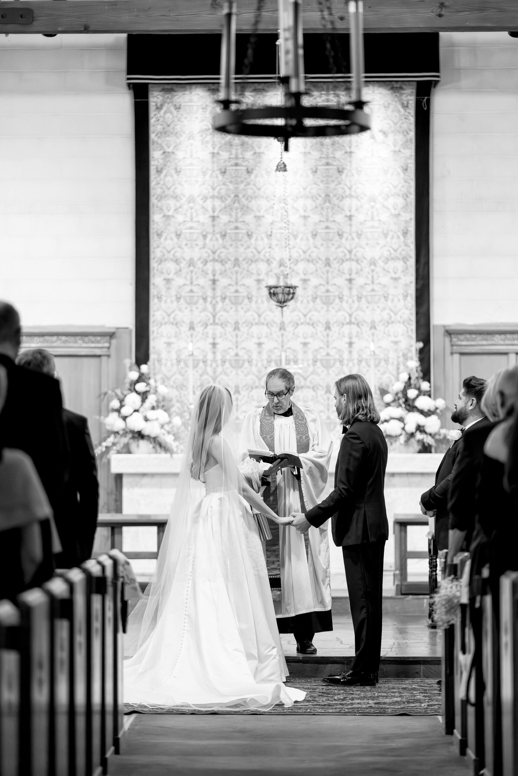 Bride and groom hold hands at end of aisle during St. Michaels Episcopal wedding