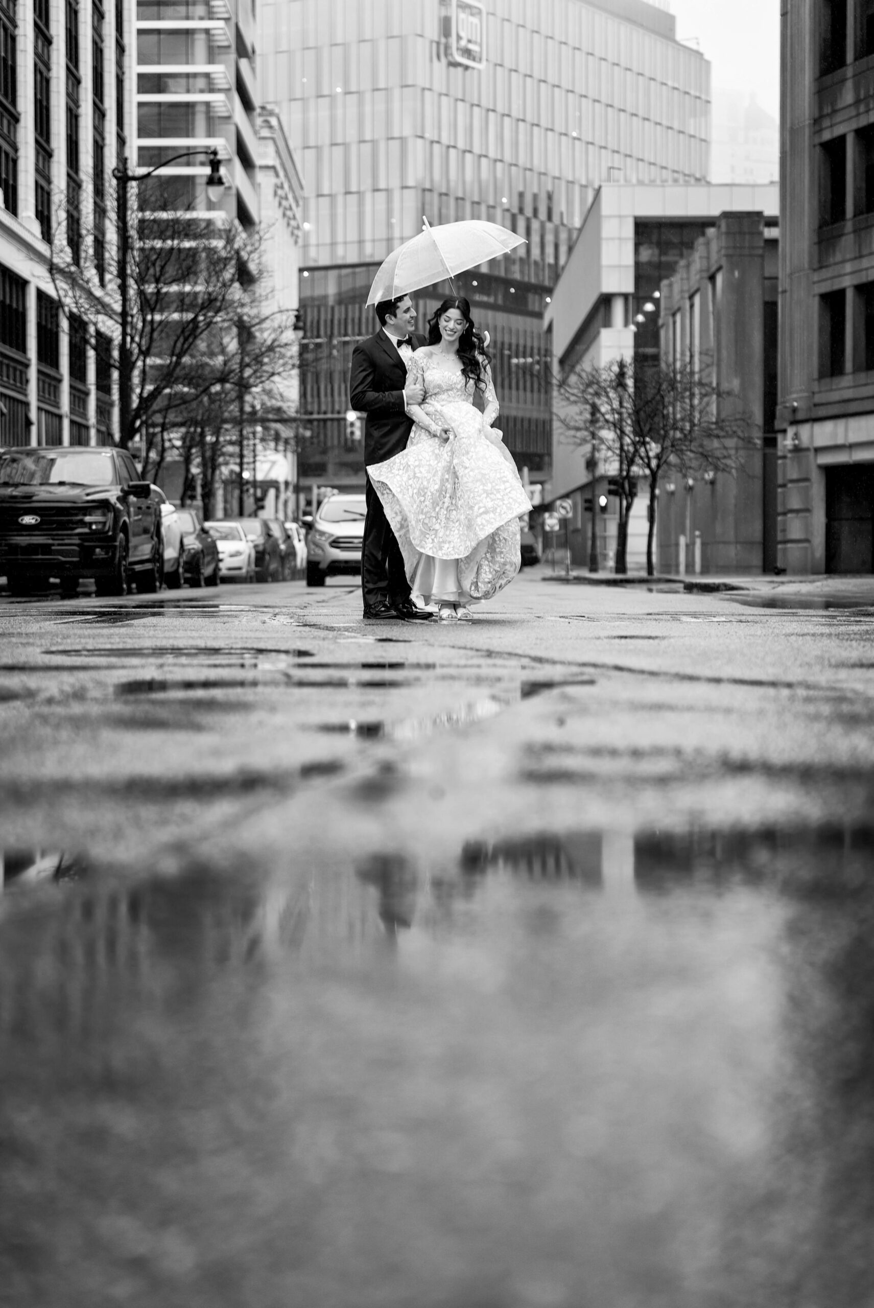 Bride and groom in rain on wedding day in the city of Detroit. 